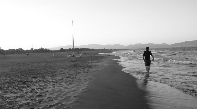 Hier ist ein einsamer Wanderer an einem spanischen Strand zu sehen. Eine Reise, in diesem Fall zu Fuß
