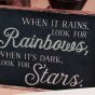 Hier ist ein Bild von einer Postkarte zu sehen, auf der die englische Aufschrift: "When it rains, look for rainbows, when its dark, look for stars" steht